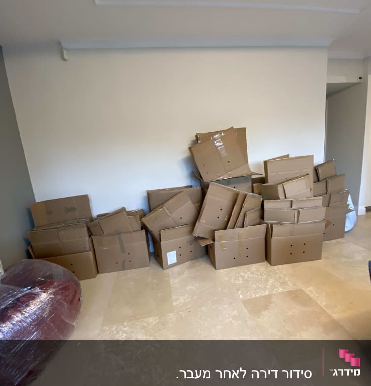 קופסאות קרטון מוערמות על הרצפה בחדר ריק